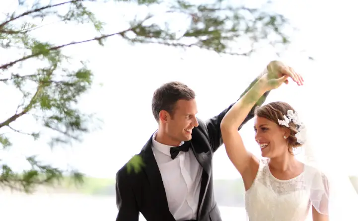 A-bride-and-groom-laughing-while-dancing