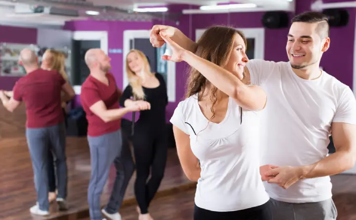 A smiling couple enjoying a wedding dance lesson