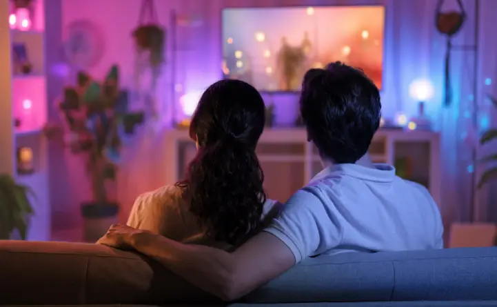 A couple sitting together and watching an online wedding dance tutorial